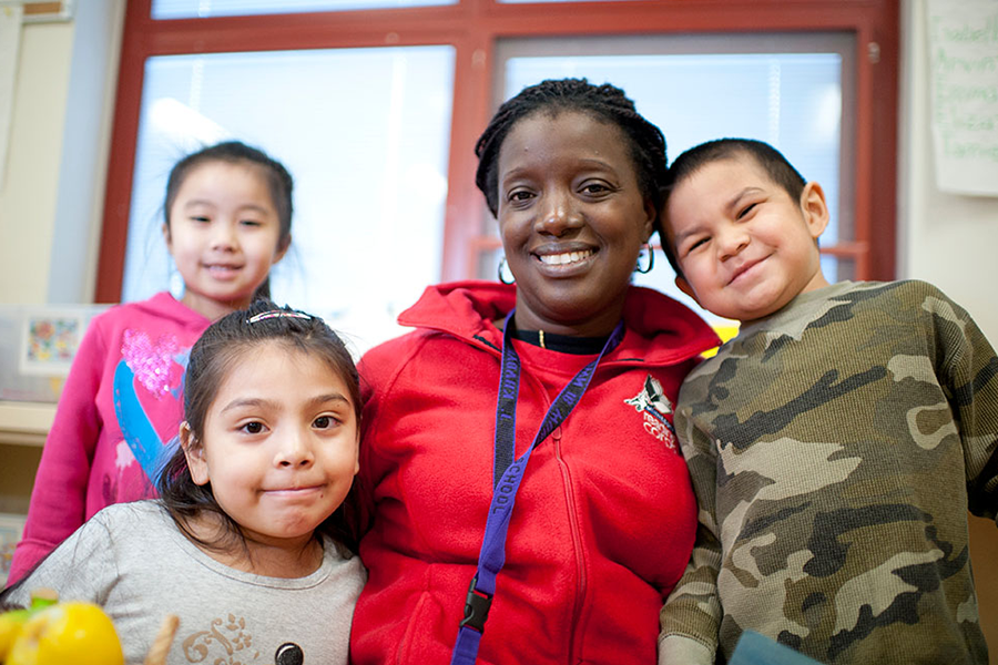 AmeriCorps volunteer posing with three young children